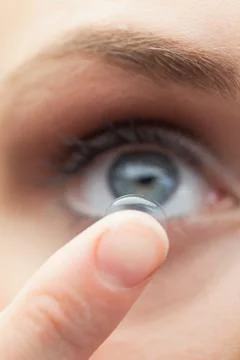 Extreme close up on cute model applying contact lens Stock Photos