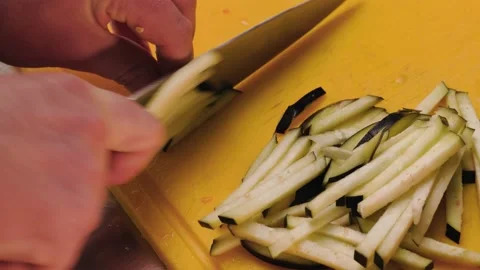 Extreme close up of cutting vegetables. The cook cuts eggplant with knife. Stock Footage 232418077