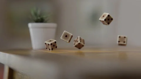 Extreme Close up of Dice cubes falling on a wooden table and a flower pot on  Stock Footage 253557531