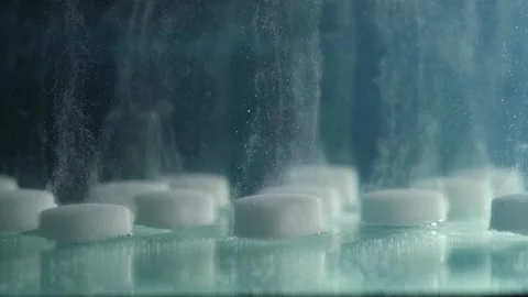 Extreme close-up of dissolving a salt tablet in water Stock Footage 148877127