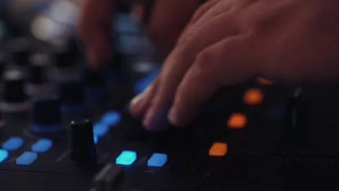 Extreme close-up of a DJ's hand repeatedly pushing a fader knob up and down on Stock Footage 346420671