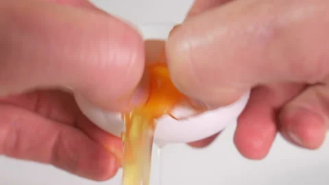 Extreme close-up of an egg being cracked in hands and poured out Stock-Footage 159458200