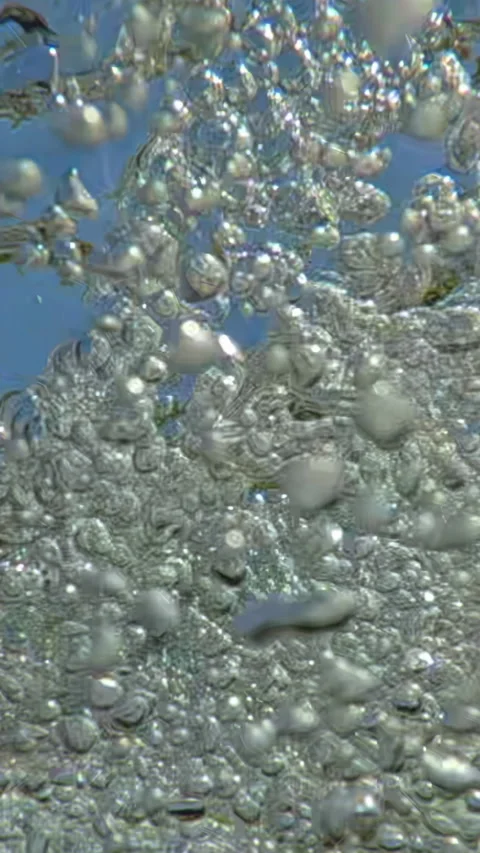 Extreme close-up of an endless stream of air bubbles floating downstream of Vídeo Stock 346395946