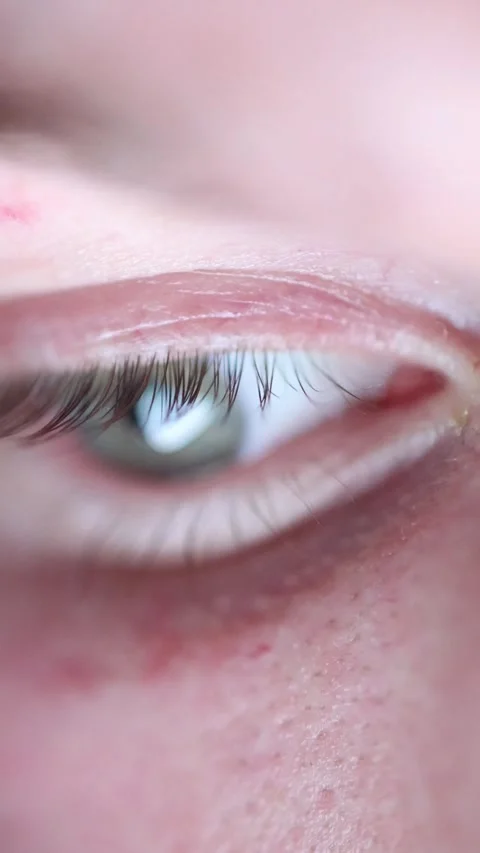 Extreme close up eye reacting to shocking content Video stock 329755887