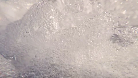 Extreme close-up of fast rushing turbulent foaming water stream, slow motion Stock Footage 326327046