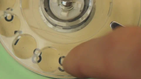 Extreme close-up finger inserting into a number slot and turning plastic dial Stock Footage 337665268