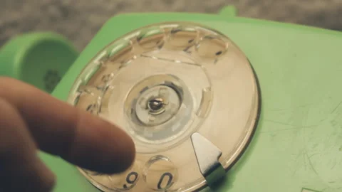 Extreme close-up finger rotating the clear plastic dial of a vintage telephone 스톡 동영상 337318390