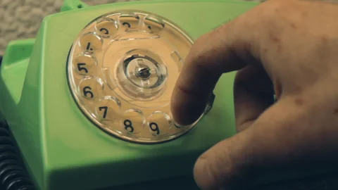 Extreme close-up finger turning plastic dial of retro green landline telephone Stock Footage 337141042