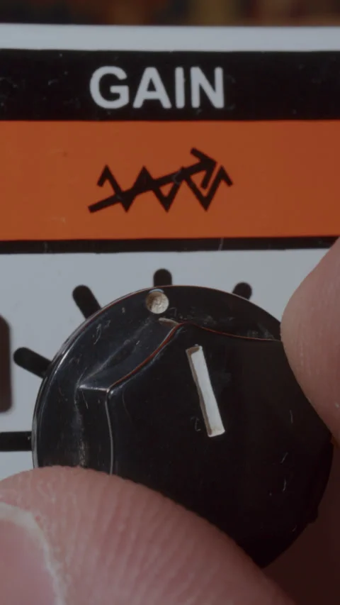 Extreme Close Up of Fingers Adjusting Gain Knob on Vintage Guitar Amplifier Stock-Footage 342454332