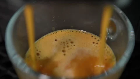 Extreme close-up of freshly brewed espresso flowing into a transparent glass cup Stock Footage 342325811