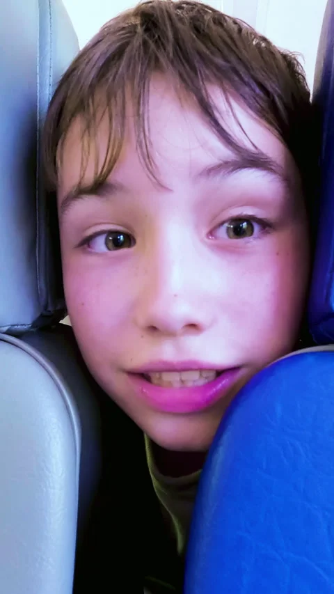 Extreme close up of a funny school age boy peeking and making faces between Stock Footage 338397492