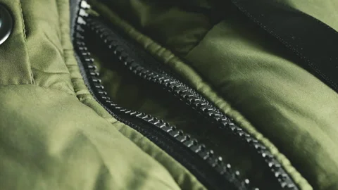 Extreme close up of a green quilted jacket zipper mechanism. Stock Footage 346188412