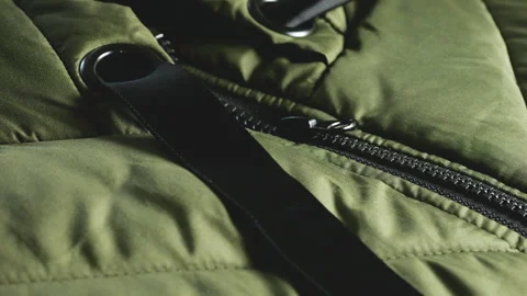 Extreme close up of a green quilted jacket zipper mechanism.  Stock Footage 346189327