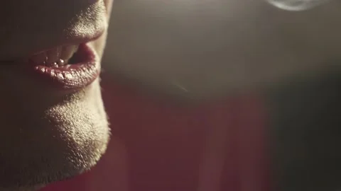 Extreme close-up, guy takes out cigarette from smiling mouth and exhales smok Stock Footage 224298444