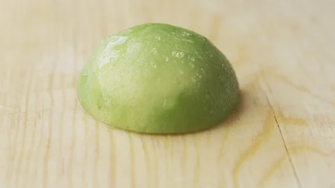 EXTREME CLOSE UP A HALF OF LEMON BEING CUT Video stock 107301227