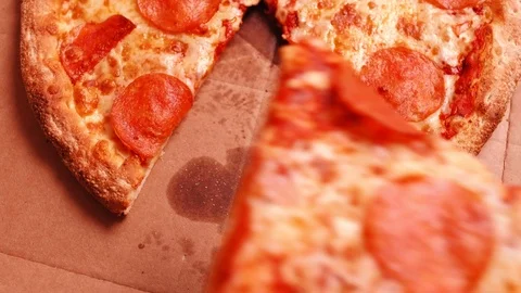 Extreme Close-up of hand putting a pepperoni pizza slice back into delivery box Stock Footage 123660623