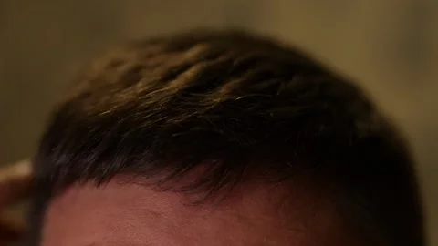 Extreme close-up of a hand touching short, dark hair. Stock Footage 328657454