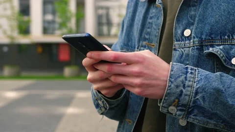 Extreme close-up hands of unrecognizable man typing online message using mobile Video stock 196118515