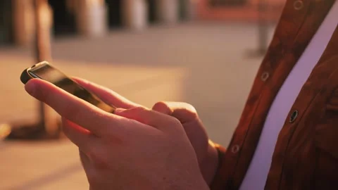 Extreme close-up hands of unrecognizable man typing online message using mobile Stock Footage 243374645