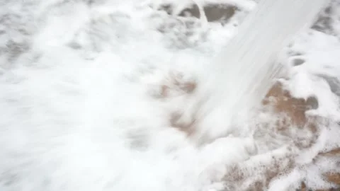 Extreme Close-Up of High-Volume Water Stream Crashing into Muddy Basin Vídeos de archivo 334464495