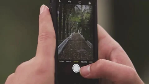 Extreme close up of Human Hands Holding Phone And Taking Photo in an empty space Stock Footage 138216929