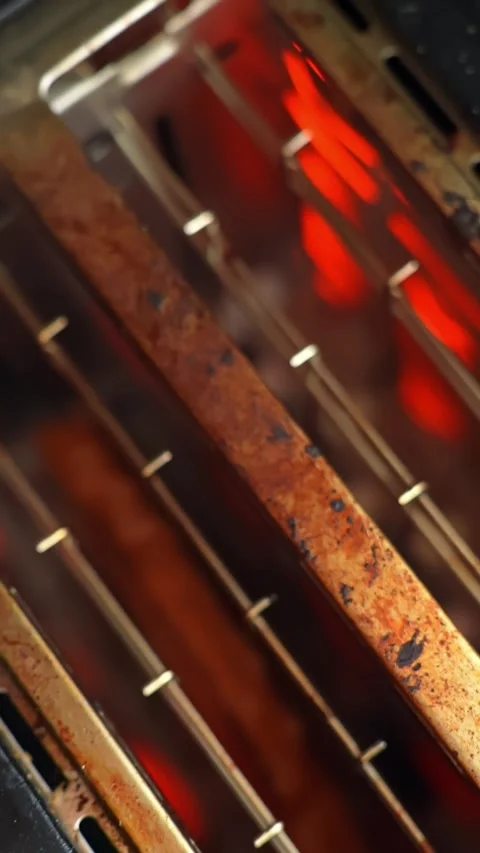 Extreme close-up inside a toaster with glowing red heating elements and metal Stock Footage 332068338