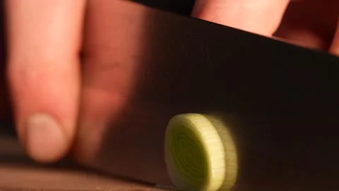Extreme Close-Up of Leek Being Trimmed With Kitchen Knife Stock Footage 321863215
