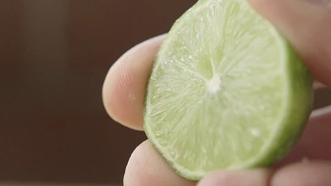 EXTREME CLOSE UP OF LEMON sQUEEZED IN SLOW Stock Footage 107302853