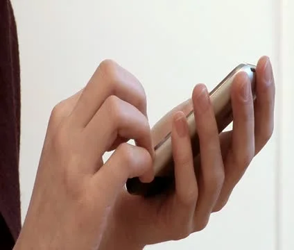 Extreme close-up lockdown shot of woman's hands holding a mobile phone and text Stock Footage