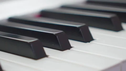 Extreme close-up low angle slider shot of piano keys moving along the keys Video stock 338158746