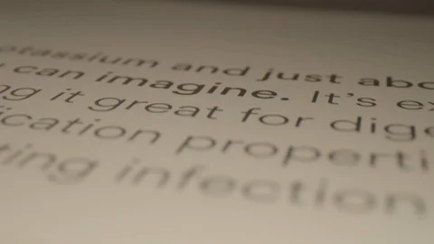 Extreme Close Up Macro of Camera Moving Back on Page of Book Stock Footage 116956696