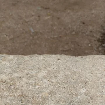 Extreme close up macro rough stone step edge blurred sandy dirt Stock Photos