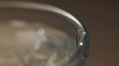 Extreme close-up macro shot of a drop of water falling on the edge of a glass Stock Footage 219496655
