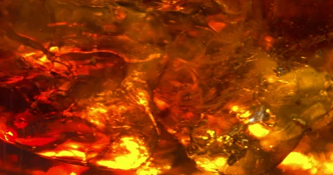 Extreme close up macro shot of ice cubes rotating in golden colored liquid with Stock-Footage 148322592