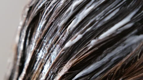 Extreme close-up macro video of wet hair strands coated with conditioner Видео 330172047