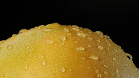 Extreme Close-Up Macro Yellow Pomelo Skin Texture With Water Drops on Black Vidéo 323132341