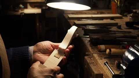 Extreme close up of a maker luthier smooths surface of violin scroll under small Stock Footage 304641734