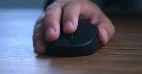 Extreme close up male hand using black computer mouse at wooden table. Closeup Stock Footage 229533475