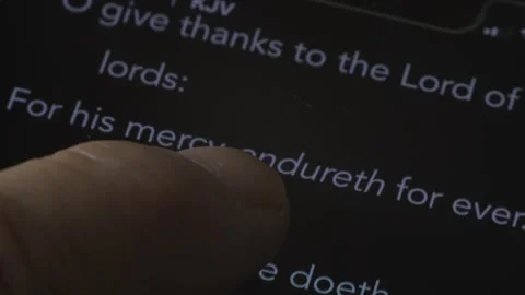 Extreme close up of a man reading the Bible on his phone Stock Footage 311946307