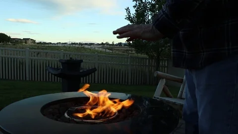 Extreme close up of man warming his hands at a backyard firepit Stock Footage 89768656
