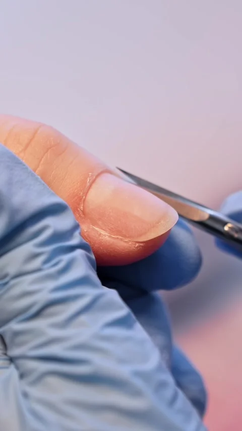 Extreme close-up of manicure scissors refining the cuticle area on a natural Stockbeeldmateriaal 333651676