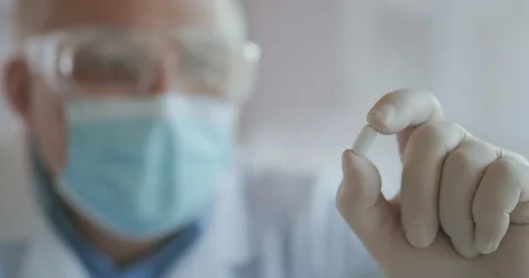 Extreme Close-up of a masked scientist developing a coronavirus vaccine holding Stock Footage 142151613
