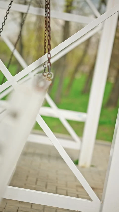 Extreme close up of a metal chain attached to a white wooden swing bench, Stock Footage 335340481