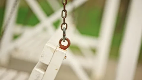 Extreme close up of a metal chain attached to a white wooden swing bench, Stock Footage 335341029