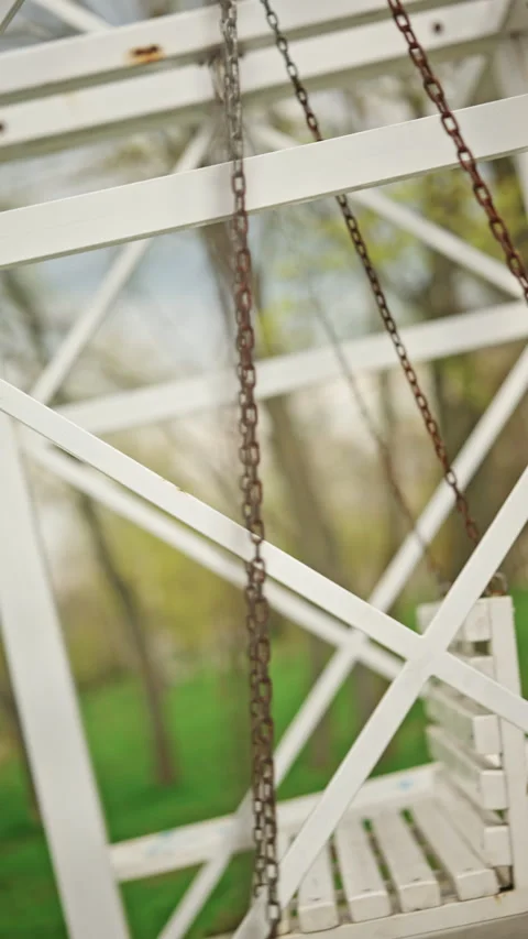 Extreme close up of a metal chain attached to a white wooden swing bench, Stock Footage 335342036