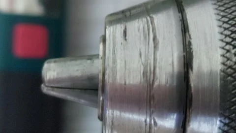 Extreme close-up of a metal drill chuck mechanism rotating Stock Footage 336460625