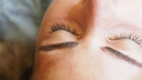 Extreme close-up of microblading pen etching precise stroke into brow with Stock Footage 307573128
