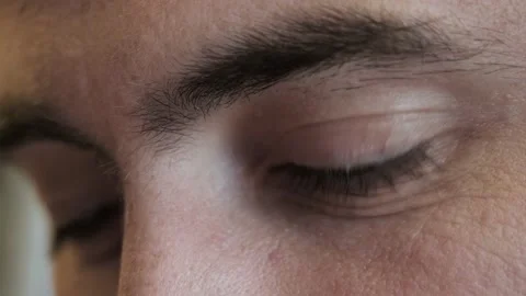 Extreme close up of middle-aged brown eyes and long dark eyelashes man reading Stock Footage 153767539