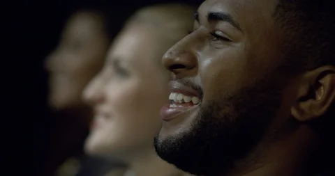 Extreme close up of a movie theatre audience laughing and enjoying a movie. Stock Footage 95620172
