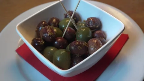 Extreme close-up moving shot (left to right) at 60fps of a bowl with olives Stock Footage 303732670